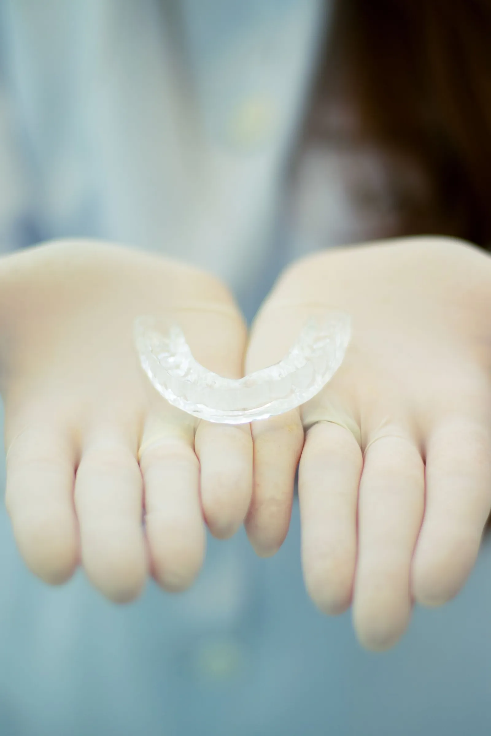 A clear retainer held in cupped hands.